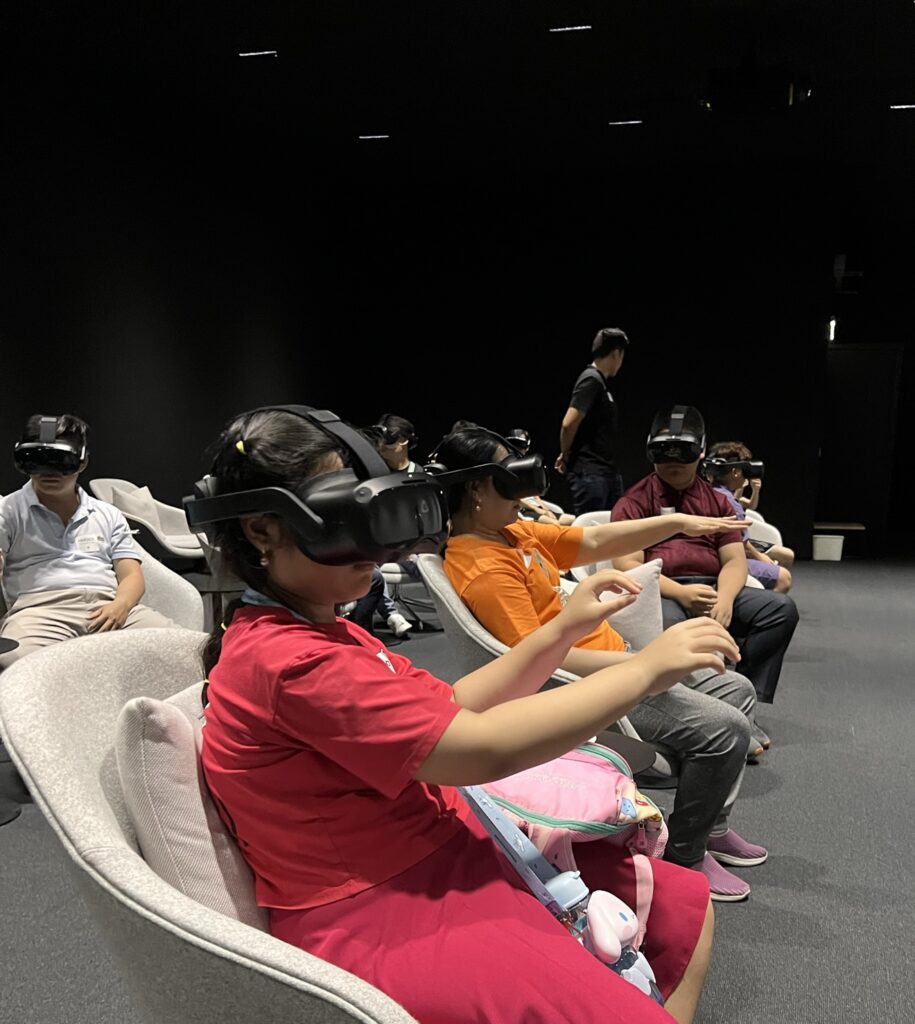 In a dimly lit room, individuals are immersed in an educational digital experience, wearing virtual reality headsets.